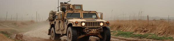 Military vehicle with EMI Shielding driving through muddy terrain in a foggy environment 